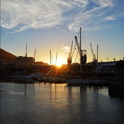 Boats in harbor at sunset