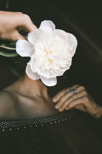 Close-up portrait with hand holding white flower