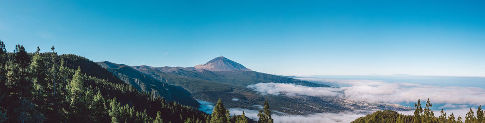 Scenic view of snowcapped mountains against blue sky