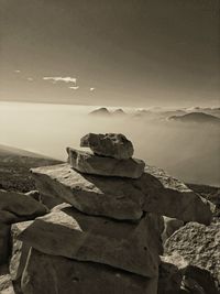 Stack of rocks by sea against sky