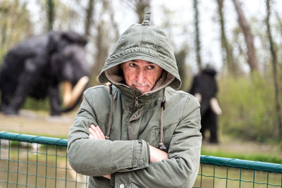 Portrait of expressive middle aged man posing in front of mammoth models in a public park