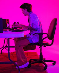 Young woman using laptop while sitting on chair