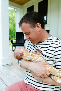 Closeup portrait of a dad holding his newborn baby daughter close