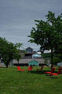 Houses and trees on field against sky