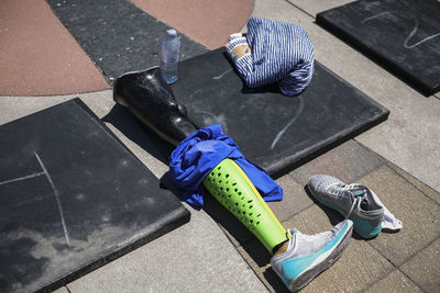 High angle view of prosthetic equipment with shoes and fabric on floor