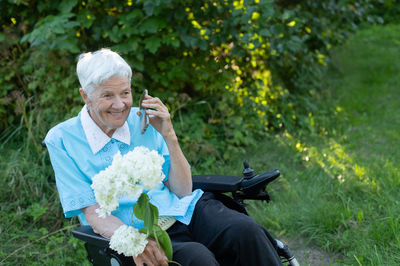 Young man using mobile phone while sitting outdoors