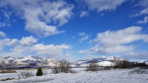 Snow covered landscape against blue sky