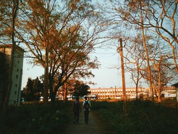 Rear view of people walking on street in city