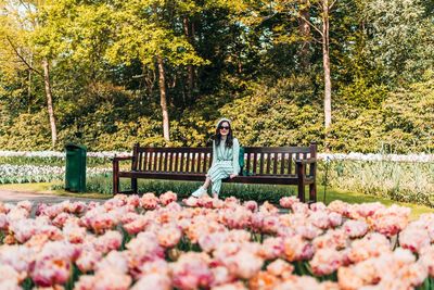 Portrait of woman sitting on bench in park