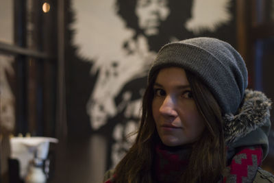 Close-up portrait of woman against poster