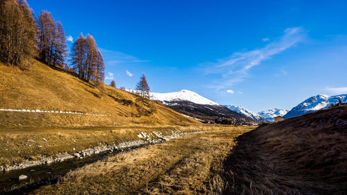 Scenic view of snowcapped mountains against blue sky