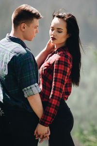 Loving young couple standing in forest