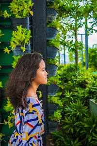 Girl standing by potted plants