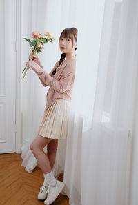 Side view of young woman holding bouquet