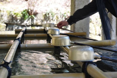 Midsection of person holding bamboo dipper