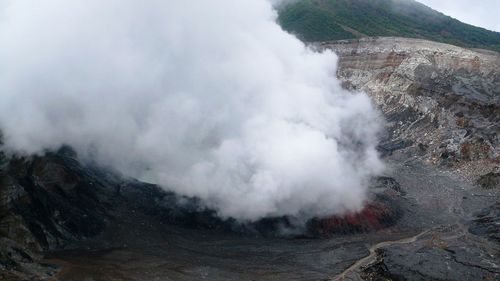 High angle view of smoke emitting from volcanic landscape