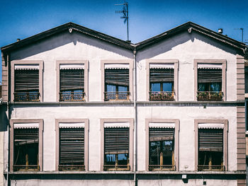 Face of a building with shutters in various positions