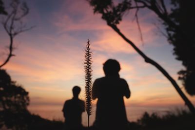 Silhouette man standing against orange sky