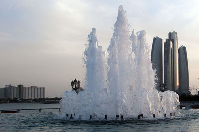 View of fountain in sea against buildings