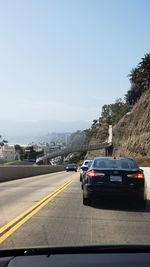 Cars on road against clear sky