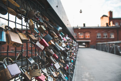 Padlocks hanging on bridge in city