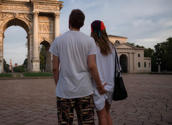 Rear view of man touching girlfriend buttocks while standing against arco della pace