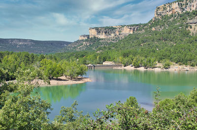 Scenic view of lake by trees against sky