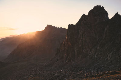 Scenic view of rocky mountains against sky during sunset