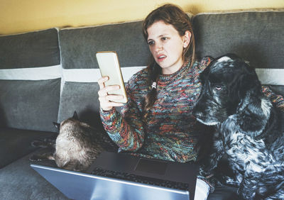 Portrait of young woman with dog on table