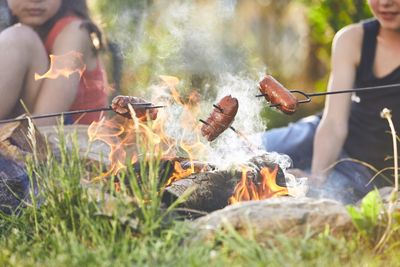 Friends preparing food in bonfire