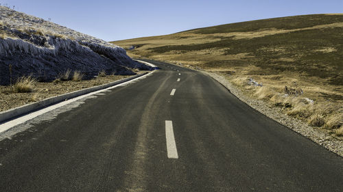 Road by mountain against sky