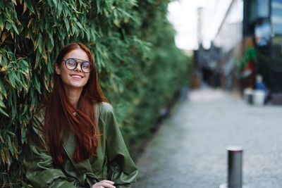 Portrait of young woman standing in city