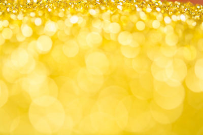 Defocused image of illuminated yellow background