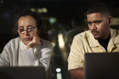 Coworkers using laptop