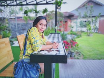 Young woman using phone while sitting on seat