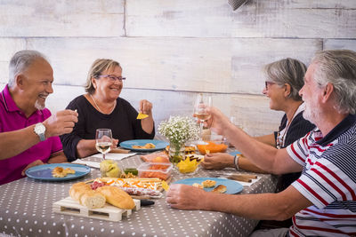 Happy friends having food at table