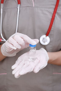 Midsection of doctor holding dental equipment