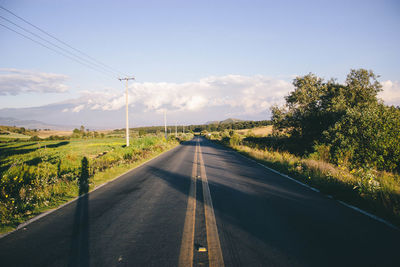 Road amidst trees against sky