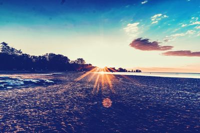 Surface level of beach against sky during sunset