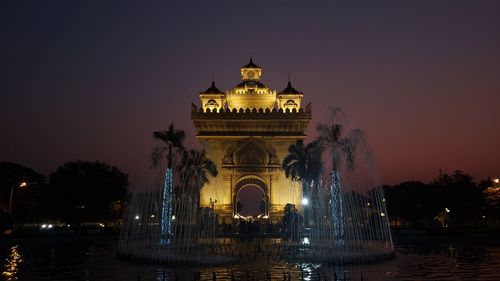 Illuminated building against sky at night