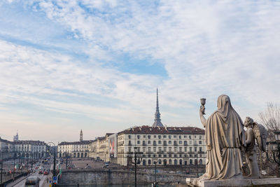 Sculptures and buildings at piazza vittorio veneto against sky