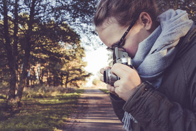 Young man with camera on tree