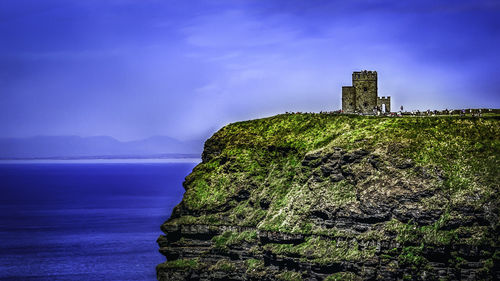 Scenic view of sea by building against sky