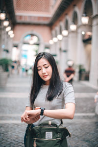 Young woman standing on street in city