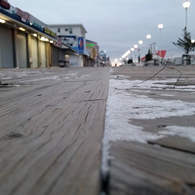 architecture, built structure, building exterior, surface level, the way forward, sky, diminishing perspective, water, beach, selective focus, sea, in a row, outdoors, walkway, sand, street, day, railing, house, no people