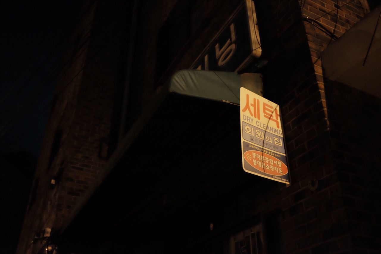 LOW ANGLE VIEW OF ILLUMINATED TEXT IN BUILDING