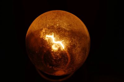 Close-up of illuminated lamp against black background