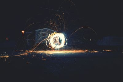 Light trails on field against sky at night