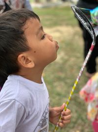 Close-up of boy blowing bubble