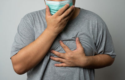 Midsection of man holding hands against white background